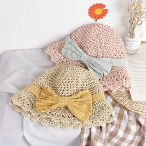 Handmade woven straw sun hats for children featuring large plaid bows and wavy brims