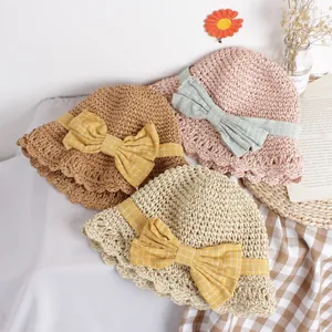 Handmade woven straw sun hats for kids with decorative bows in brown pink and beige colors