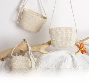Creative display of children's woven straw bags hanging on branches with dragonfly decor