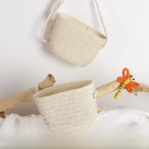 Detailed texture of straw bucket bags with cotton rope straps and dragonfly decor