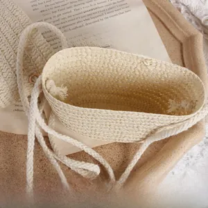 Detail of hand-woven straw crossbody bag with cotton rope strap and vintage props