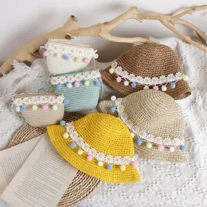 Handmade woven sun hat and crossbody bag set with colorful pom-poms and daisy lace trim
