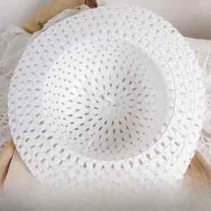 Close-up of breathable mesh texture and elastic strap on a white woven kids straw hat