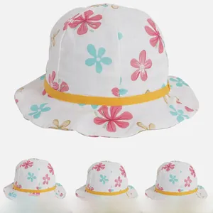 Détail d'un chapeau de soleil bébé avec motif floral, ruban jaune et bordure ondulée