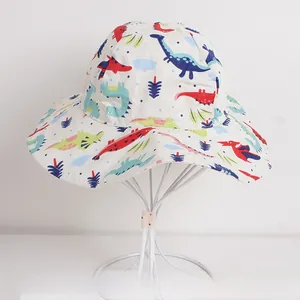 Detailed view of white kids sun hat featuring colorful dinosaur patterns and wavy brim