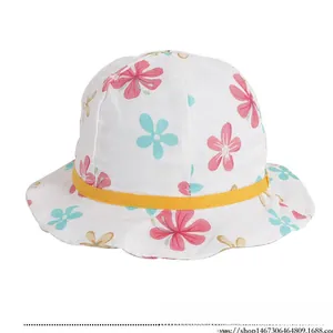 Détail d'un chapeau de soleil en coton pour bébé avec fleurs et bordure ondulée