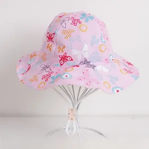 Detailed close-up of pink cotton kids bucket hat with floral butterfly patterns and wind rope