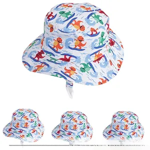 Detail of kids sun bucket hat featuring cute cartoon dinosaur surfing patterns and chin strap