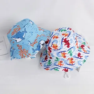 Detail of blue shark and colorful surfing dinosaur prints on cotton kids sun bucket hats
