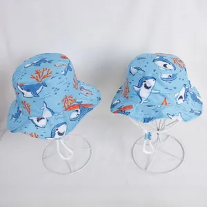 Detail of light blue kids sun hat with cartoon shark print and adjustable chin strap