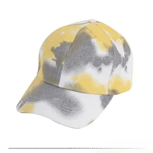 Détail du motif tie-dye jaune et gris sur une casquette de baseball en coton