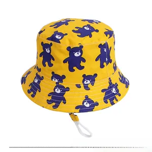 Detail of yellow kids bucket hat with purple bear prints and white adjustable chin strap