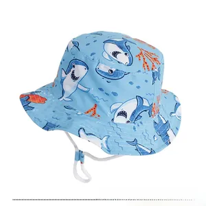 Detail of light blue kids sun hat with cartoon shark print and adjustable white chin strap