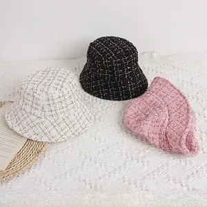 Flat lay of tweed bucket hats for children in black, white and pink with metallic yarn