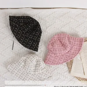 Flat lay of tweed children bucket hats in black pink and white with gold thread texture