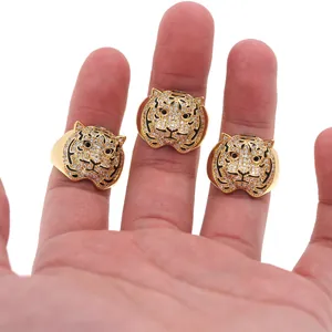 Close-up of gold-plated tiger rings with pavé cubic zirconia and black enamel stripes