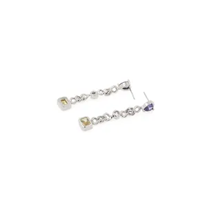 Close-up of dangling earrings with silver chain, purple, white and yellow gemstones
