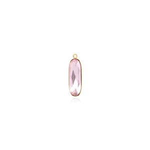 Vue macro d'un pendentif ovale en zircon rose avec cadre plaqué or 18 carats poli