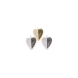 Detalle de colgantes de corazón en oro 18K con pavé de circonitas negras y blancas sobre blanco