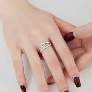 Close-up of pear-cut high carbon diamond ring with twisted band on female model hand