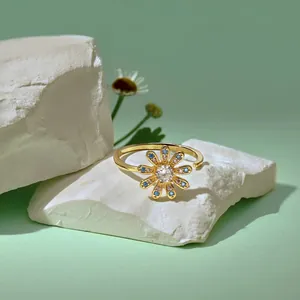 Nahaufnahme des goldenen Sonnenblumen-Drehrings mit Zirkonia auf Steinunterlage