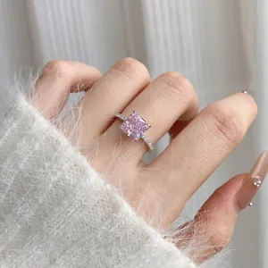 Close-up of square pink carbon diamond ring on finger with micro-pave silver band