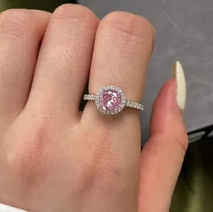 Close-up of elegant S925 silver ring featuring a pink halo diamond and paved zircon band