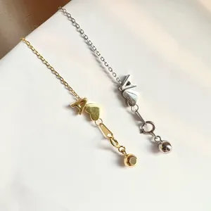 Macro shot of gold and silver S925 sterling silver heart and letter A pendants
