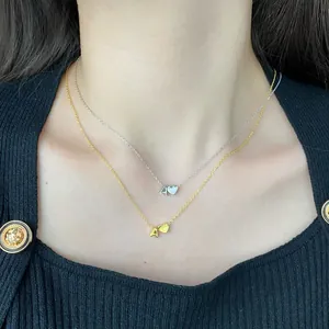 Close-up of S925 silver and gold heart necklaces with letter A pendant on a model