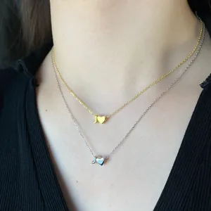 Close-up of S925 silver heart and letter J pendants on gold and silver chain necklaces