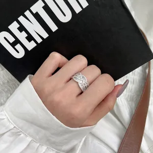 Détail macro d'une bague tressée en argent S925 sertie de zircons cubiques carrés