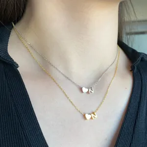 Detail of gold and silver S925 sterling silver heart necklaces with letter N pendant