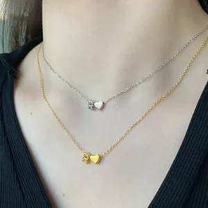 Detail of S925 silver heart and letter R pendant necklace on a model's neck