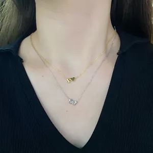 Detail of layered S925 sterling silver heart and letter S pendant necklaces for women