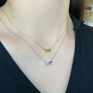 Detailed view of gold and silver S925 heart initial necklaces on model neckline