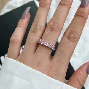 Macro shot of silver ring with five pink heart gemstones and tiny zircon accents