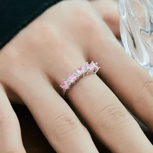S925 sterling silver ring with five pink heart-shaped zircons on a hand with soft lighting
