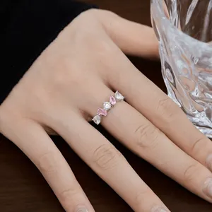 Détail d'une bague en argent S925 avec zircons roses et blancs sur le doigt