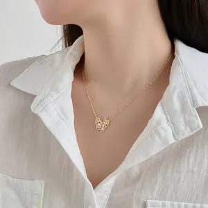 Detailopname van de gouden vlinder hanger ketting met zirkonia op de nek van het model