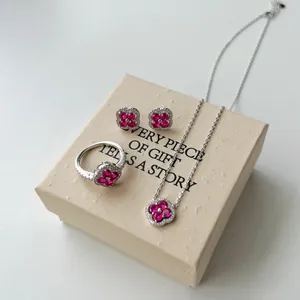 Détail d'une parure trèfle en argent S925 avec pierres roses sur un coffret cadeau