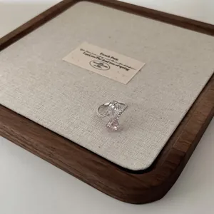 Macro view of pear-cut pink and white gemstones on a pavé-set silver open ring