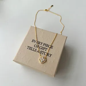 Détail du collier trèfle en argent s925 doré avec zircons sur un coffret cadeau