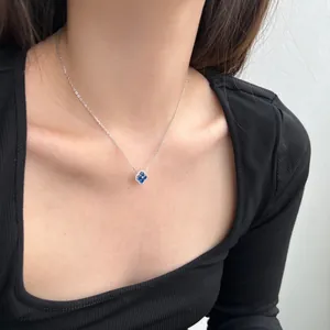 Détail du collier en argent s925 avec pendentif trèfle bleu sur le cou d'un modèle