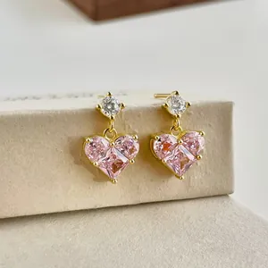 Close-up of heart-shaped pink zircon earrings with gold plating and prong setting