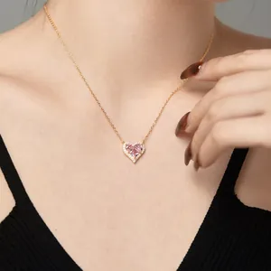 Detailaufnahme des herzförmigen rosa Zirkon-Anhängers mit Goldkette am Modelhals