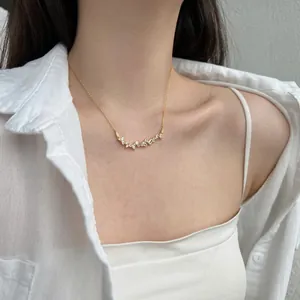 Close-up of geometric zircon pendant on a gold necklace worn by a female model