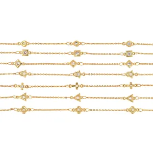 Dettaglio di catene placcate oro 18K con ciondoli geometrici micro-pavé in zircone lucido