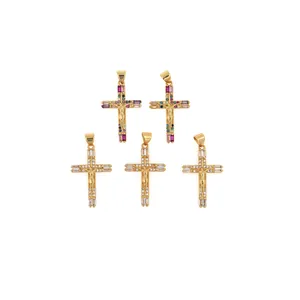 Detalle macro de cinco colgantes de cruz bañados en oro 18K con circonitas y relieve de Jesús