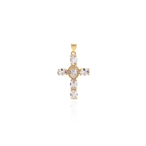 Macro detail of 18K gold plated cross pendant with oval cubic zirconia on white background