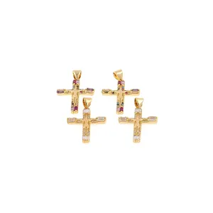 Detalle de colgantes de cruz chapados en oro 18K con circonitas de colores y relieve
